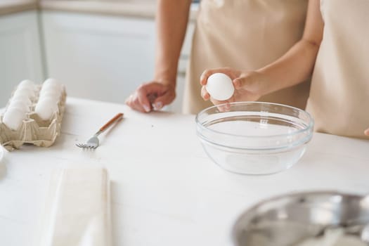 Close up photo of woman anf her daughter cooking dough in kitchen