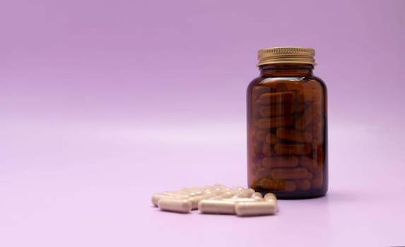 Brown Glass Bottle, Flattered Softgel Capsules OF Slippery Elm On Purple Violet Background, Copy Space for Text. Herbal Supplement, Ulmus Fulva, Natural Remedy. Horizontal plane.