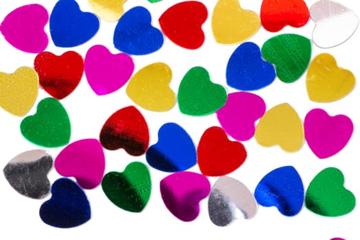 Color shiny hearts on the table for Valentine's Day. Isolated over white background