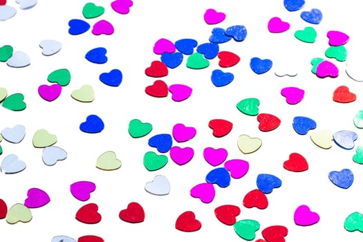 Color shiny hearts on the table for Valentine's Day. Isolated over white background