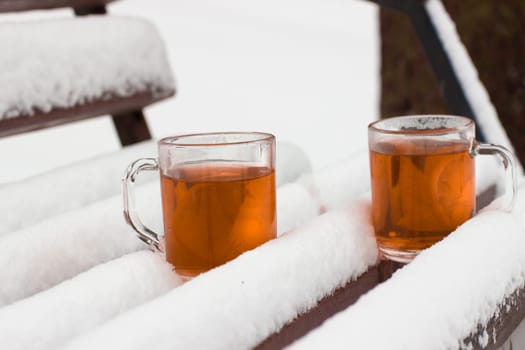 Two cups with hot tea on a  snow background