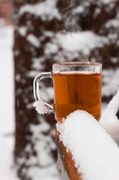 Cup with hot tea on a  snow background