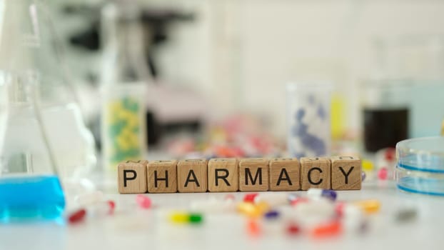 Pharmacy word on wooden cubes near many medicines. Pharmaceutical industry concept