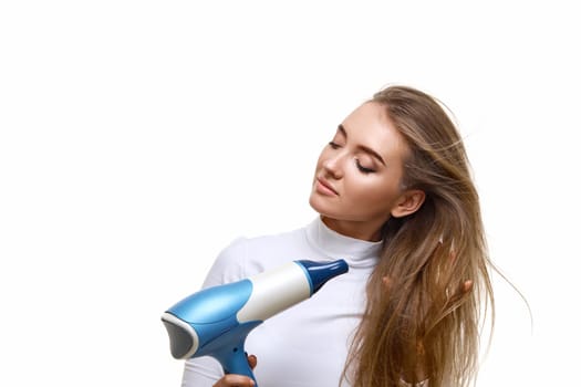 Portrait of attractive cheerful girl drying long hair isolated on white background