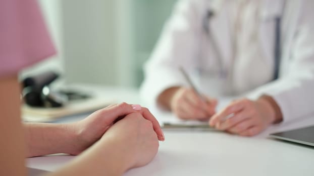 Patient hands on table during visit to doctor in clinic closeup. Medicare concept