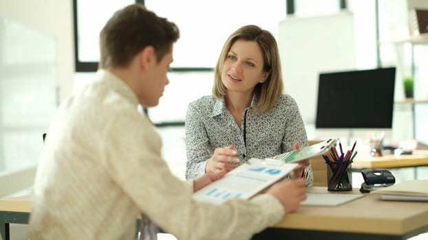 Business partners studying information on documents with charts in office. Business meeting concept