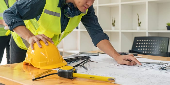 engineer working on blueprints and construction plans. Building engineers calculate and draft building construction drawings, civil engineering, and construction business concepts.