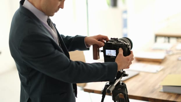 Man in suit business blogger adjusting camera in conference room. Business education online concept