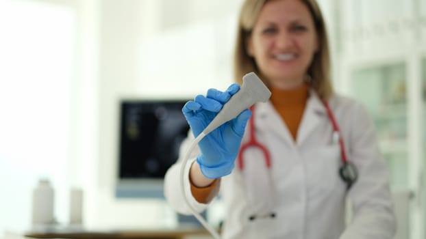 Smiling woman ultrasound diagnostic doctor holding transducer in clinic closeup. Instrumental diagnostics of gynecology examination of pregnant women concept