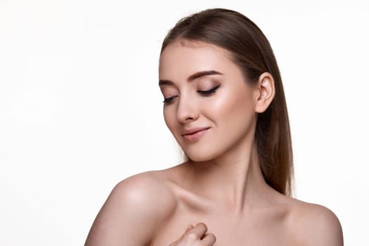 beautiful amazing young woman touching her shoulder and enjoying perfect soft clean skin on white background