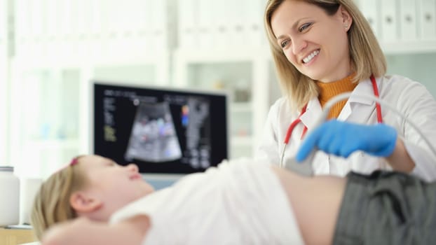 Doctor pediatrician making ultrasound examination of abdominal organs of child in clinic. Diagnosis and treatment of diseases of internal organs in children concept
