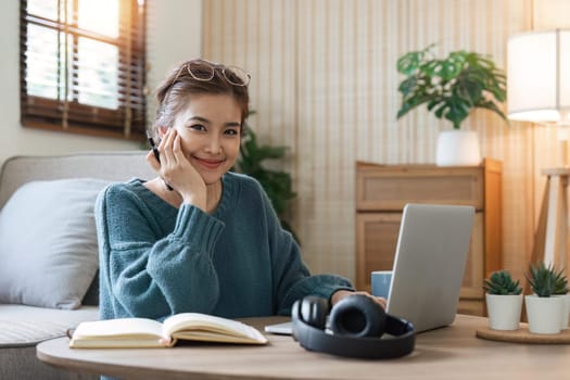 Image of woman cheery happy positive cute beautiful business woman sit indoors in home using laptop computer.