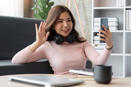 woman making video call on smartphone with family or friends happily.