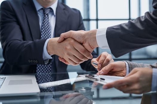 Businesspeople or lawyers shaking hands finishing up meeting or negotiation in sunny office. Business handshake and partnership