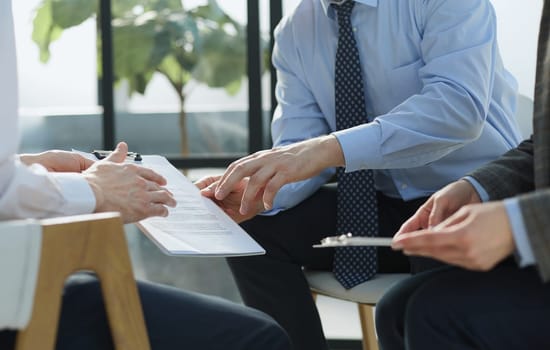 Two business employees reviewing documents in open folder.