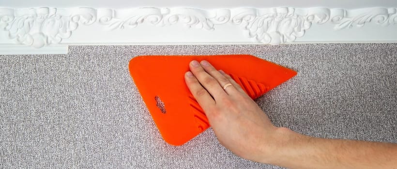 A man glues wallpaper, repairs the house. Selective focus