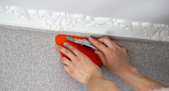 A man glues wallpaper, repairs the house. Selective focus