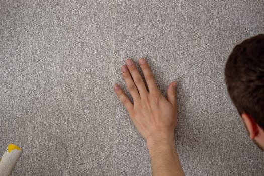 A man glues wallpaper, repairs the house. Selective focus