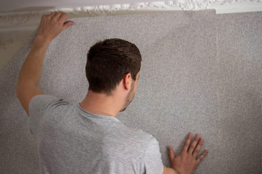 A man glues wallpaper, repairs the house. Selective focus