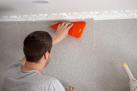 A man glues wallpaper, repairs the house. Selective focus