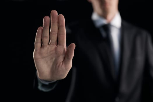 Man's hand shows a palm on a dark background