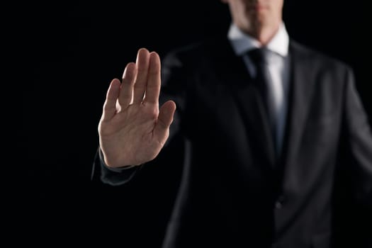 Man's hand shows a palm on a dark background