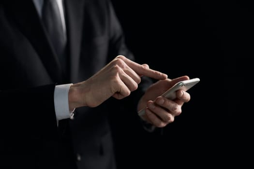 closeup of a businessman presses a finger on the smartphone screen.