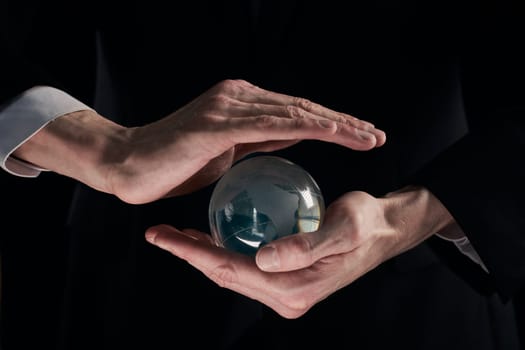 businessman's hands are covered with a glass ball