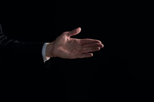 Man's hand shows a gesture with a palm on a black background.