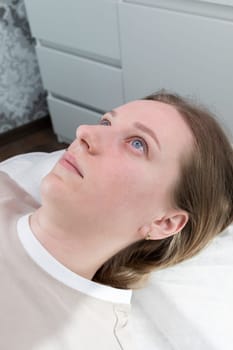 Portrait Of Young Caucasian Woman After Eyelash Lamination Procedure, Lash Treatment Lying on Couch. Vertical Plane High quality photo.