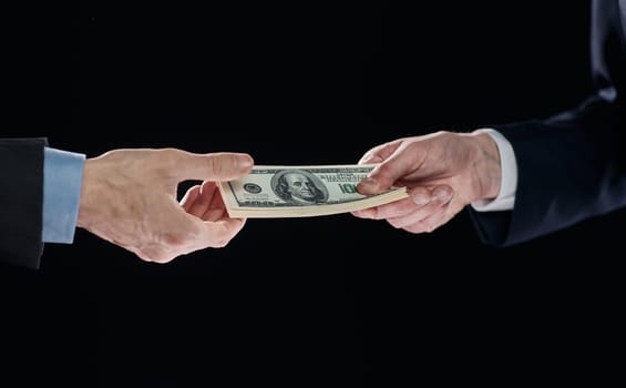 few bills in his hand on a dark background. Copyspace.