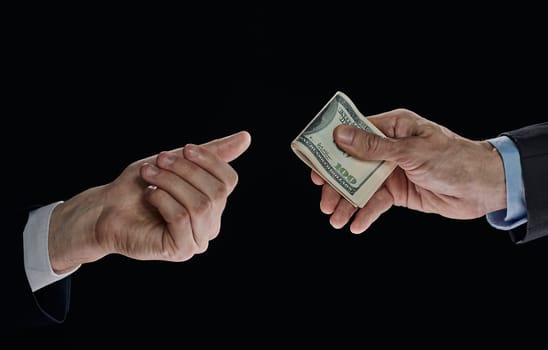 few bills in his hand on a dark background. Copyspace.