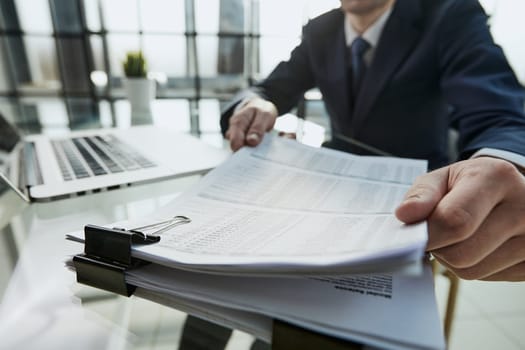 Close-up Of A Businessman Analyzing Financial Report In The Office