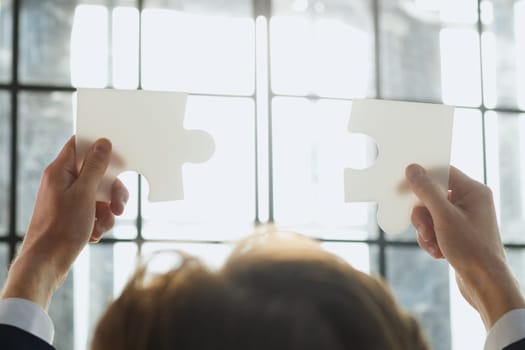 Close-up of business hands connecting jigsaw puzzle, success and goal achievement, the last jigsaw is the link of all the pieces. strategic planning or a solution for the management.