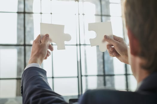 Close-up of business hands connecting jigsaw puzzle, success and goal achievement, the last jigsaw is the link of all the pieces. strategic planning or a solution for the management.