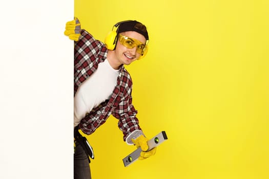 smiling professional builder in work clothes in helmet with level . copy space for text