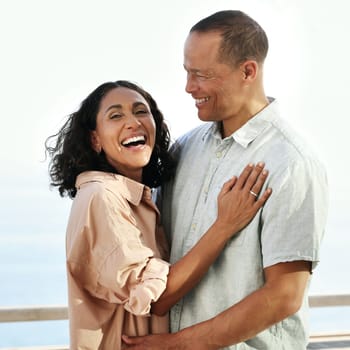 Portrait, laughing and senior couple by beach, hug and enjoying quality time on holiday or vacation. Love, comic and retired happy man and woman laugh at funny joke or comedy while having fun by sea