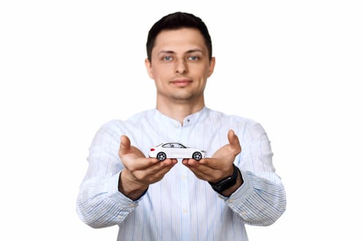 man holding a toy caron white background. dealerships offer car . Car insurance. focus on car