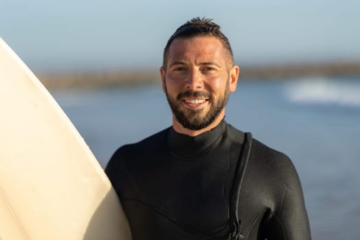 Smiling man surfer in a wetsuit. Portrait