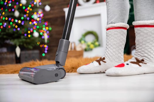 Thorough vacuuming of the floor before the celebration of an important Christian beheading. A decorated living room for Christmas.