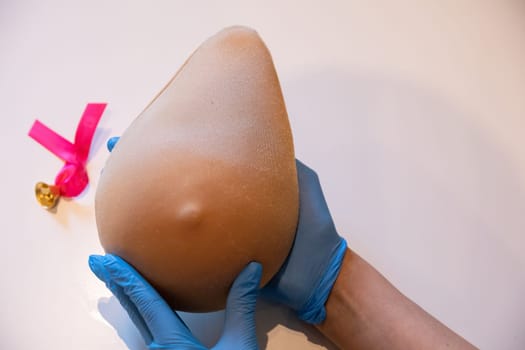 Demonstration of how to examine your breast with one hand on the phantom of Lady M. Professional demonstration of breast compression technique during the examination.