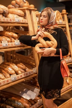 The young pretty woman in the bread depatment at the supermarket