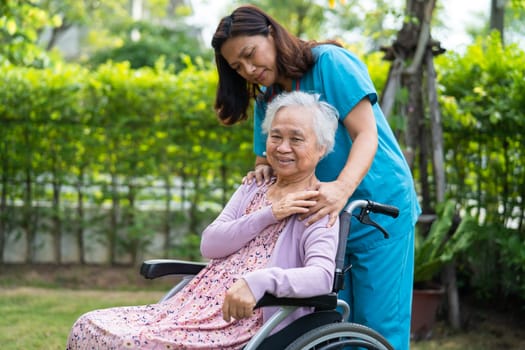 Doctor help and care Asian senior woman patient sitting on wheelchair at park in nursing hospital ward, healthy strong medical concept.