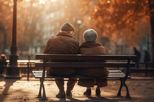 Grandma and grandpa, elderly people, aged old married couple sitting on a bench in the park and talking, enjoying nature.