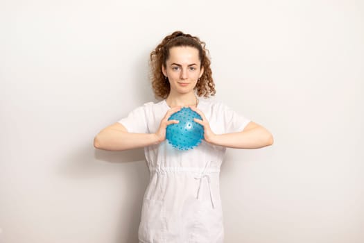Rehabilitation Specialist, Physical Therapist In White Medical Clothes Holds Massage Ball With Pimples In Therapeutic Cabinet. Health Specialist, Rehabilitation. Horizontal. High quality photo
