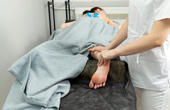 Rehabilitation Specialist, Physical Therapist Makes Foot Massage To Patient With Cerebral Palsy, Scoliosis. Health Specialist, Rehabilitation. Horizontal plane. High quality photo