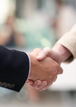 Shot of a coworkers shaking hands in an office.