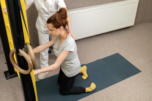 Disabled Child With Physician Does Physical Exercises In Gym. Kid With Special Needs. Rehabilitation. Cerebral Palsy. Motor Disorder. Horizontal plane. High quality photo