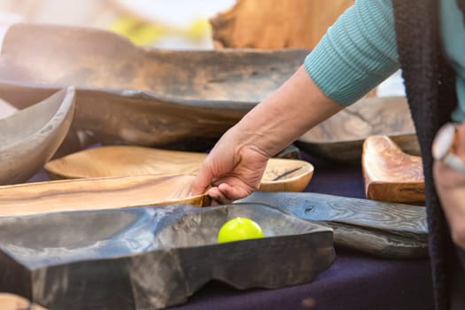 Manufacture and sale of wooden utensils. Large plates and trays made from exotic wood roots, handmade furniture and accessories purchase, craft and small business concept. High quality photo