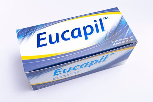 Eucapil box, fluridil lotion, cosmetic product for topical use in androgenetic alopecia, hair loss on blue background. Close up, horizontal. Bialystok, Poland: 22.02.2023. High quality photo